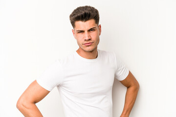 Obraz premium Young caucasian man isolated on white background frowning face in displeasure, keeps arms folded.