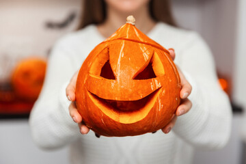 Holidays, Halloween, woman holding a pumpkin on her outstretched hands, close-up