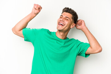 Young caucasian man isolated on white background celebrating a special day, jumps and raise arms with energy.