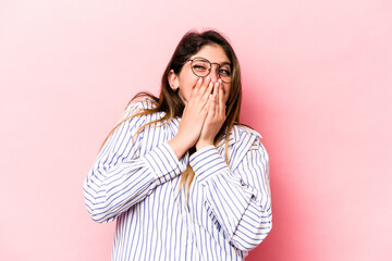 Young caucasian woman isolated on pink background laughing about something, covering mouth with hands.