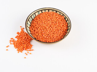 Red lentils in a green bowl on a green background. Red lentils macro. 