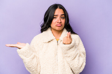 Young hispanic woman isolated on purple background showing that she has no money.