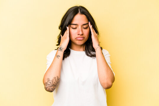 Young Hispanic Woman Isolated On Yellow Background Having A Head Ache, Touching Front Of The Face.