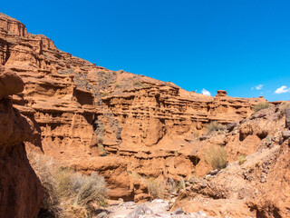 Red tales from clay. Issyk-Kul region in Kyrgyzstan. Beautiful mountain landscape. Tourism and...