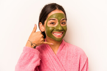 Young hispanic woman wearing a facial mask isolated on white background showing a mobile phone call gesture with fingers.