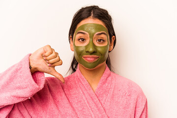 Young hispanic woman wearing a facial mask isolated on white background showing a dislike gesture, thumbs down. Disagreement concept.