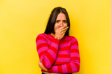 Young hispanic woman isolated on yellow background scared and afraid.