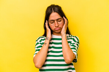 Young hispanic woman isolated on yellow background having a head ache, touching front of the face.
