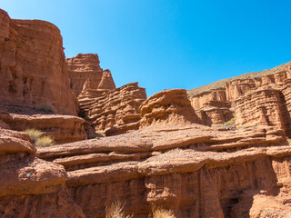 Red tales from clay. Issyk-Kul region in Kyrgyzstan. Beautiful mountain landscape. Tourism and...