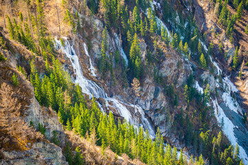 Frozen water in the waterfall in mountain of Altai Republic. Siberia, Russia