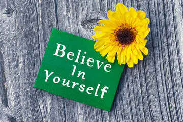 Believe in yourself word on green wooden cube with and sunflower. - obrazy, fototapety, plakaty