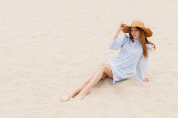 attractive woman in a straw hat on the sand. summer mood