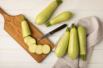 Fresh organic zucchini whole and slices on a white wooden table. Vegan food. Healthy vegan food. Fresh organic product. Vegetables. Healthy food. Copy space.