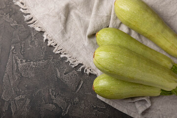Fresh organic zucchini whole and slices on a black wooden table.Vegan food.Healthy vegan food. Fresh organic product.Vegetables. Healthy food.Copy space.