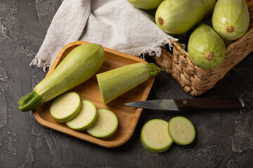Fresh organic zucchini whole and slices on a black wooden table.Vegan food.Healthy vegan food. Fresh organic product.Vegetables. Healthy food.Copy space.