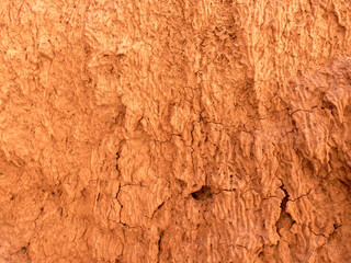 Texture of red clay. Natural natural patterns. Dry red background closeup.
