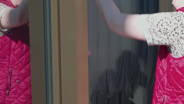 Close up view of woman cleaning window in house. Sweden.