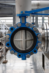 An industrial open butterfly valve in a stainless steel pipe system, suitable for the transport of liquids or gases