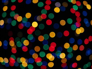 Colorful abstract background. Multicolored garland with bokeh effect on a black background.