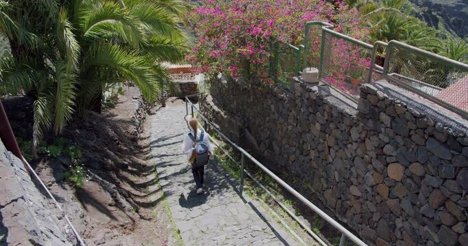 Masca Gorge and village, Tenerife. Beautiful young woman tourist with backpack visit the location.