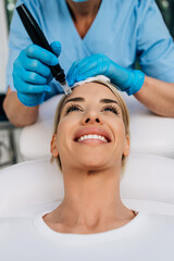 Microneedle mesotherapy. Beautiful woman receiving microneedling rejuvenation treatment.