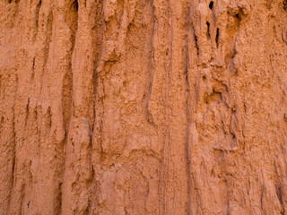 Texture of red clay. Natural natural patterns. Dry red background closeup.
