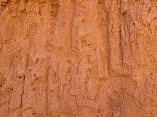 Texture of red clay. Natural natural patterns. Dry red background closeup.