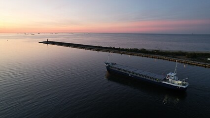 Cargo ship on the background of the fiery sunset of the Baltic Sea.
