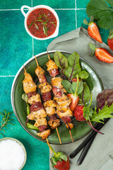 Baked chicken with strawberry on a green background