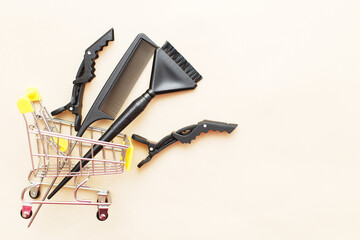 various hairdressing tools with shopping cart on a beige background. beauty salon concept