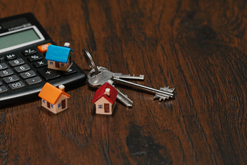 Toy house keys and calculator. Real estate purchase concept.