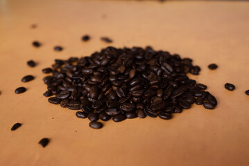 Pile of coffee beans on orange background