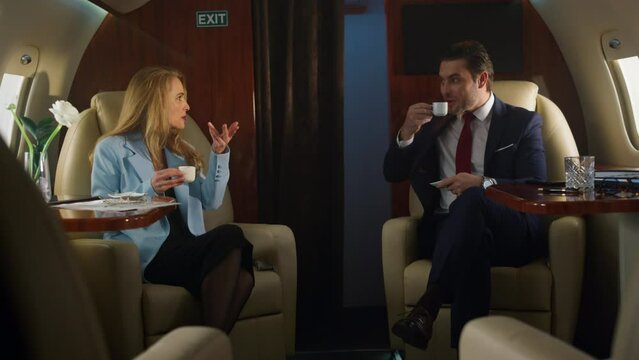 Business team drink coffee on first class flight. Company partners talk on jet