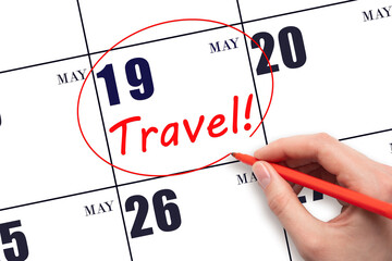 Hand drawing a red circle and writing the text TRAVEL on the calendar date 19 May. Travel planning.
