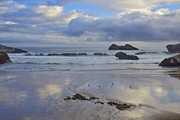 Sandy beach at the rocky coast of the ocean . The Way of St. James, Northern Route, Spain