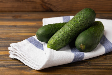 Fresh organic cucumbers whole and slices on wooden texture background.Ingredient for salad.Fresh vegetables.Vegan food.Healthy food.Fresh organic vegetable.Copy space.