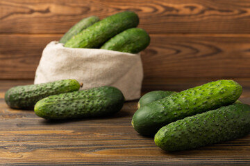 Fresh organic cucumbers whole and slices on wooden texture background.Ingredient for salad.Fresh vegetables.Vegan food.Healthy food.Fresh organic vegetable.Copy space.
