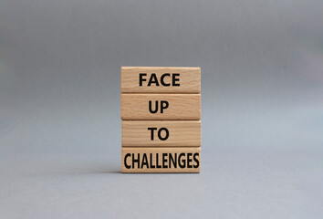 Face up to challenges symbol. Wooden blocks with words Face up to challenges. Beautiful grey background. Business and Face up to challenges concept. Copy space.