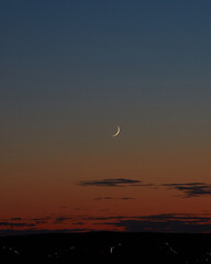 small crescent on a red coloured dawn sky