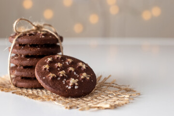 on the table is a stack of round chocolate Christmas cookies with sugar stars and salt tied with rope