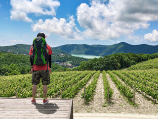 Man with backpack at vineyard and lake Abrau background in Abrau-Dyurso travel destination