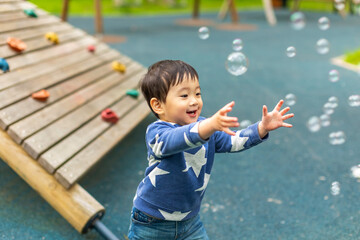 Little Asian boy is playing on the playground with happy face in summer and happily running around...