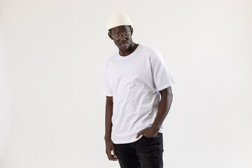 African american man in a white t-shirt stands on a white background.. Mock-up.
