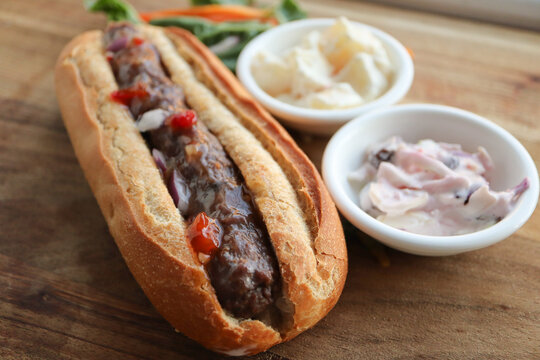 Boerewors roll. South African braai. Sausage with relish on a crusty roll. With coleslaw and potato salad 
