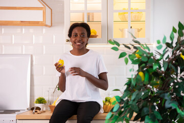 African american woman in white t-shirt in the kitchen.