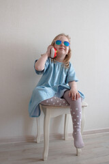 girl in sunglasses playing with a toy phone © Ekaterina Malieva