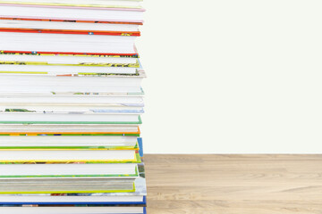 Stack of colorful children books on the table close up with copy space.