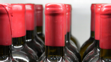 Close-up of many wine bottles with red sealing wax corks