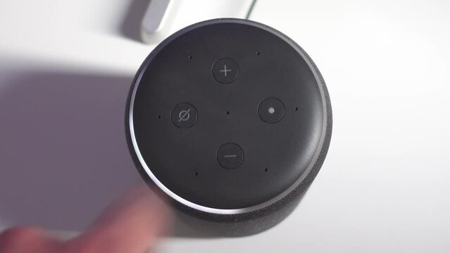 Decreasing volume of the speaker. Smart home vocal assistant in a modern house.