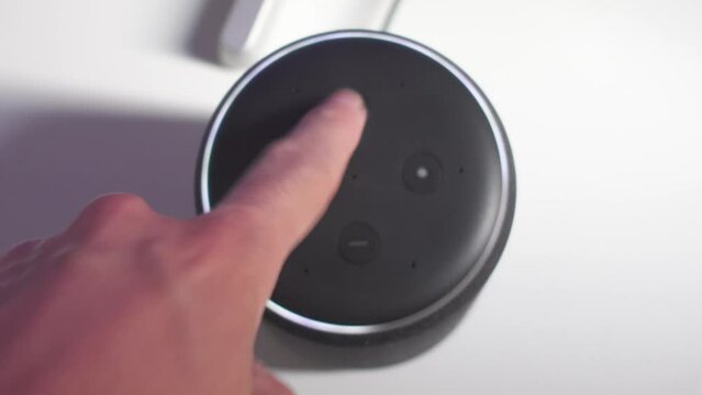 Increasing volume of the speaker. Smart home vocal assistant in a modern house.